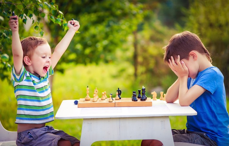 Chico inteligente aprende a jugar al ajedrez solo en su habitación en casa