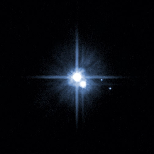 Plutón en el centro de la imagen, con su satélite Caronte pegado a él. Más a la derecha, otras dos lunas descubiertas en 2005, Hydra y Nix. Foto: NASA, ESA, H. Weaver (JHU/APL), A. Stern (SwRI) y HST.