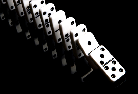 White dominos on a reflective, black background
