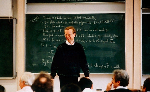 Mítica fotografía de Andrew Wiles, que recorrió el mundo entero, obtenida al final de la tercera conferencia del ciclo “Formas modulares, ecuaciones elípticas y representaciones de Galois” que impartió en Cambridge en junio de 1993, tras sus palabras “… y esto demuestra el último teorema de Fermat. Creo que lo dejaré aquí”; después llegaría el descubrimiento del error en la prueba y más de un año de trabajo extra para completar la demostración del último teorema de Fermat